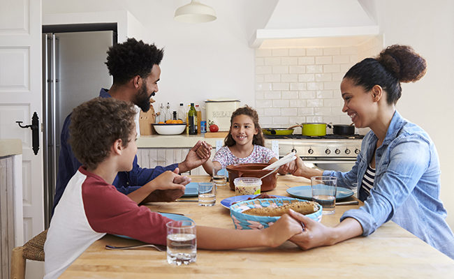 Family hold hands around the kitchen table adoption foster Lifeway Research