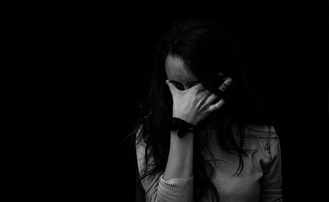 woman head in hands sad domestic abuse myths church