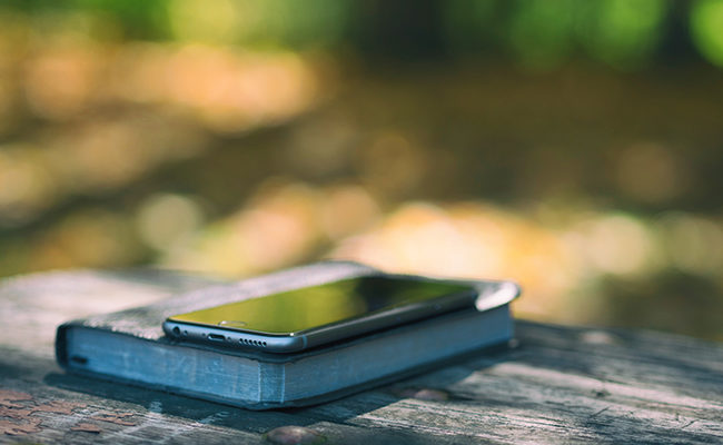 Phone laying on top of Bible - Do you spend more time in the Bible or on your phone?