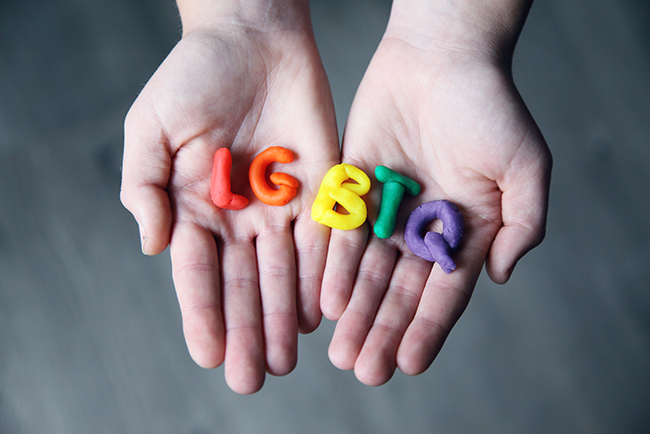LGBTQ play-dough letters in someone's hands - LGBTQ churches 