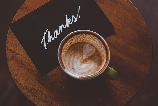 Thank you note laying on table with coffee cup - show appreciation for pastors