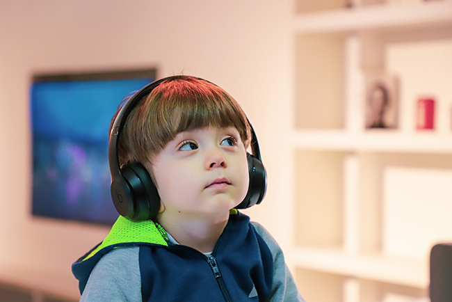 Kid with autism wearing headphones - Kids with disabilities