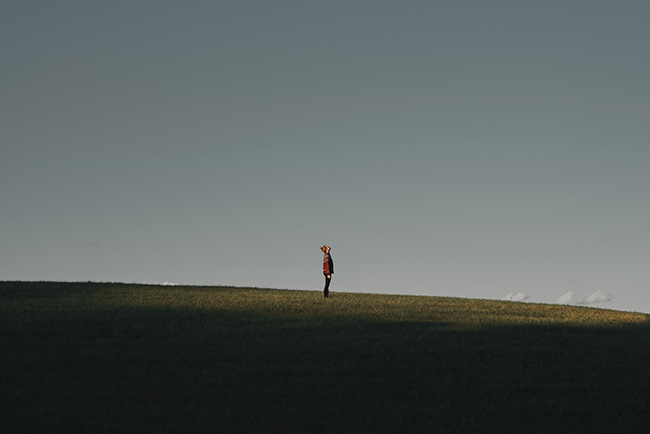 Person standing in empty field looking at sky - the wonder of advent