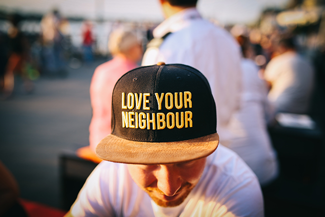 community service - man serving wearing "love your neighbor" hat