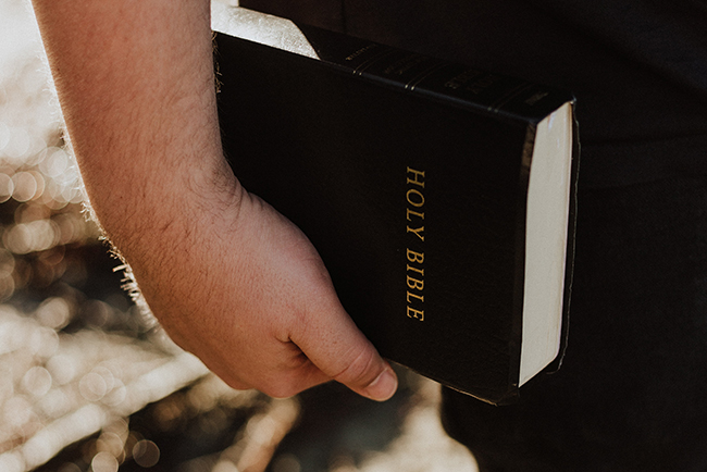 man holding bible by side - go to local church