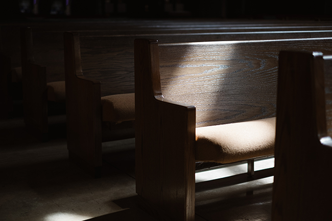 Light from window hitting empty pews, Americans attending church
