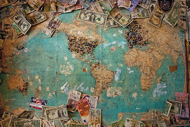 world map with money laid out on it - pastors preach on money