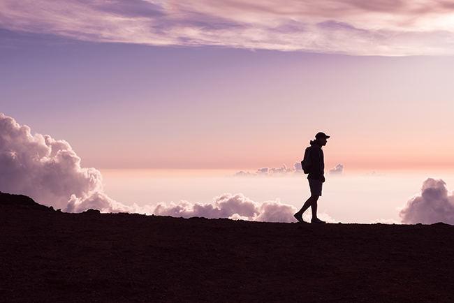 Man walking on ridge, sunset behind him; your body