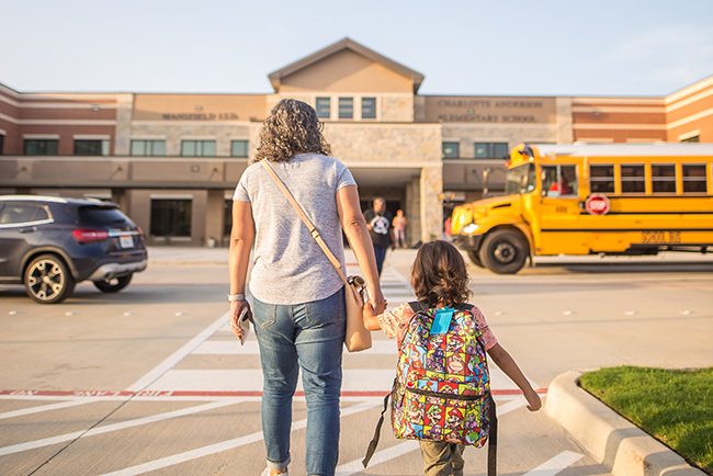 Mother leading child to school bus - back-to-school