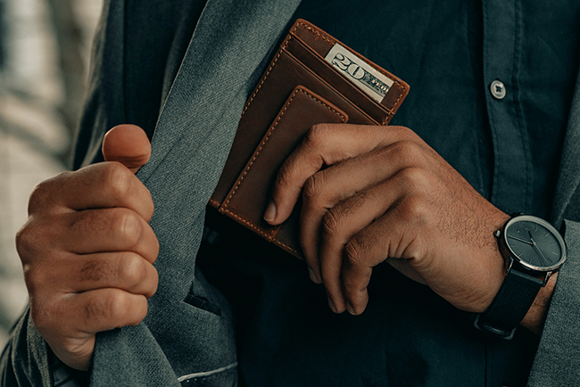 Man removing wallet from jacket pocket - financial changes