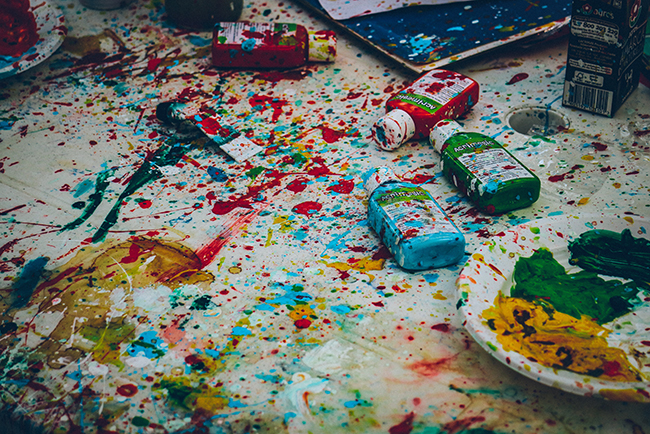 Splattered paint on drop cloth and paint bottles - messy church