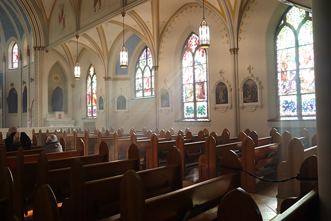 wooden pews inside church with stained glass window - Do Jews, Christians, and Muslims worship the same God?