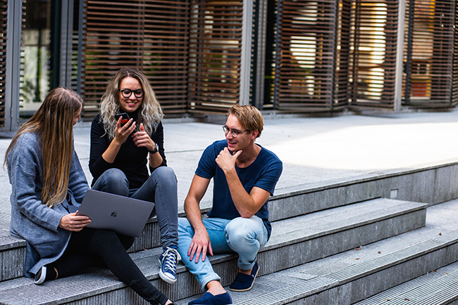 Three young adults sitting on steps talking - connecting passion with purpose
