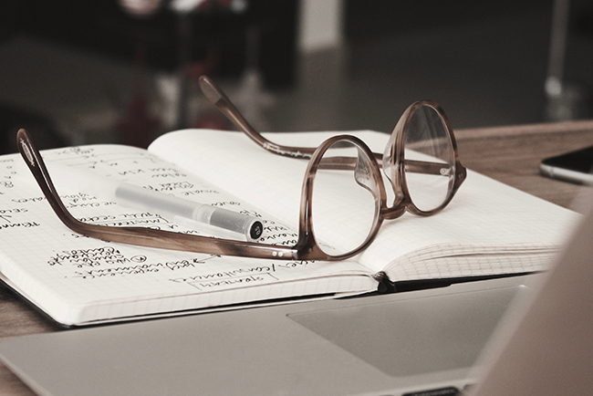 eye glasses laying on top of open notebook - using statistics in your sermons