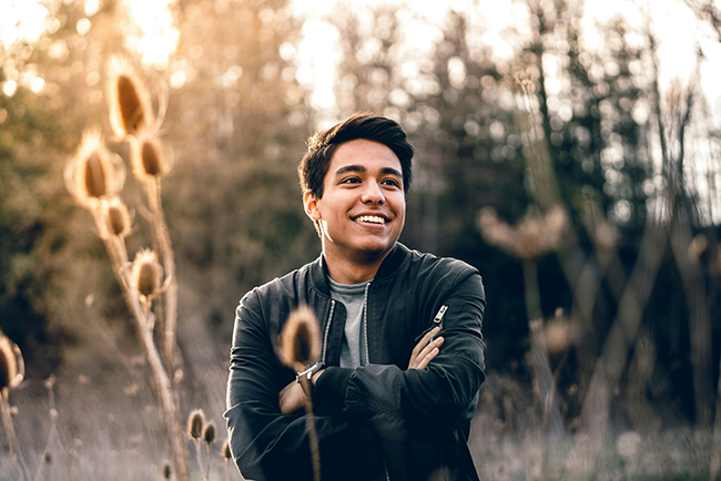 Hispanic man standing in field smiling - Hispanic pastors