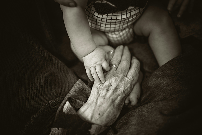 Baby's hand touching old woman's hand - generational values