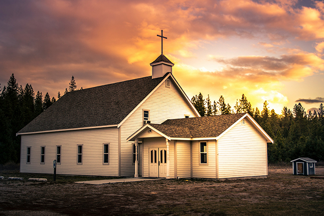 small church with sun setting behind it - women in small churches