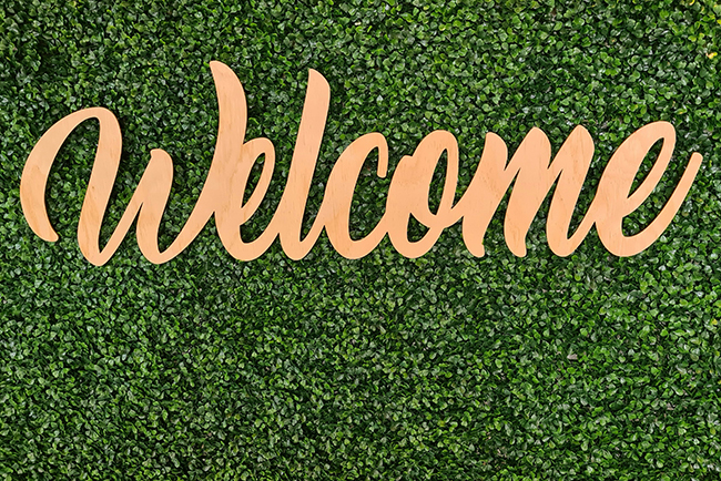 welcome sign over greenery - churches welcome guests